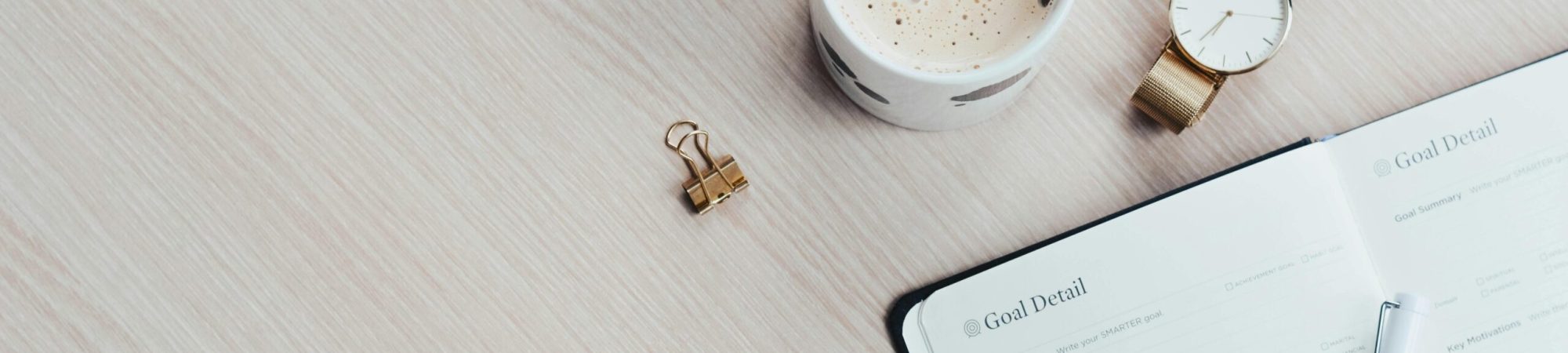 Mug, Watch, and Planner Book on Brown Wooden Surface