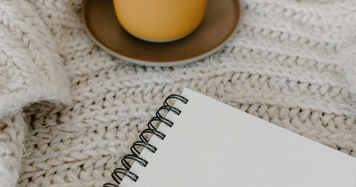 pexels-photo-6690205-6690205 A warm, cozy scene featuring a blank notebook and a mug on a knitted blanket. Perfect for relaxation.